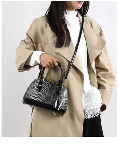 Detail of snake skin pattern and shiny patent leather on the shell-shaped handbag