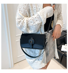 Détail du sac bandoulière en tweed et cuir avec boucle fer à cheval porté par un mannequin