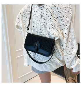 Detail of black crossbody bag with tweed texture flap and leather body on model