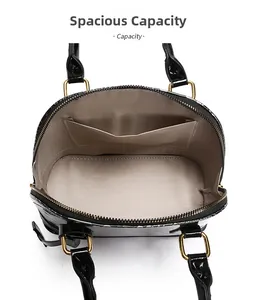 Inside view of black patent shell bag featuring beige fabric lining and a side pocket