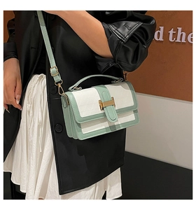 Detail of mint green contrast bag showing 3D triangle texture and gold metal buckle