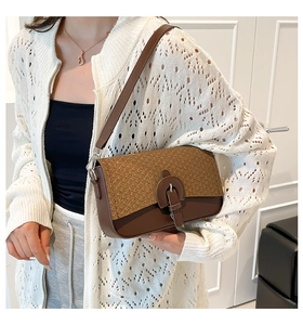Close-up of brown textured leather crossbody bag with vintage buckle on model