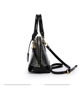 Detail of snake pattern shell handbag showing glossy patent leather and gold hardware