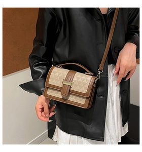 Detailed view of two-tone crossbody bag with geometric texture and gold H-buckle