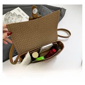Interior view of brown crossbody bag showing capacity for phone and cosmetics