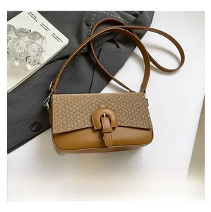 Detail view of vintage caramel crossbody bag showing leather and straw texture next to a phone