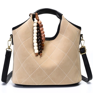 Khaki quilted bucket bag with black trim and vintage wooden bead accessory