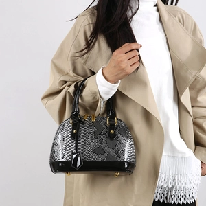 Snake embossed shell handbag in black glossy patent leather with gold hardware