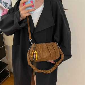 Brown ruched cloud bag with wooden bead charm and long crossbody strap for women