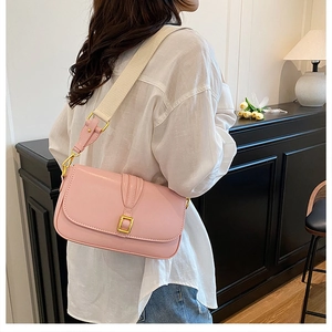 Pink crossbody bag detail showing gold hardware and stylish wide fabric shoulder strap