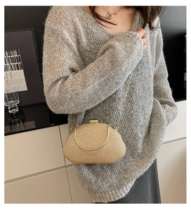 Close-up of champagne gold evening clutch with metallic texture and sleek chain strap