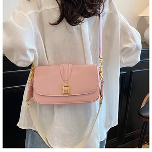 Detail of pink crossbody bag showing the gold buckle and detachable wide canvas strap