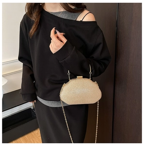 Detail of shimmering gold sequin evening bag with a metal handle and chain strap