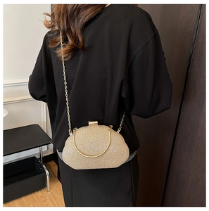 Golden clutch bag with chain strap shown on person for size and style reference