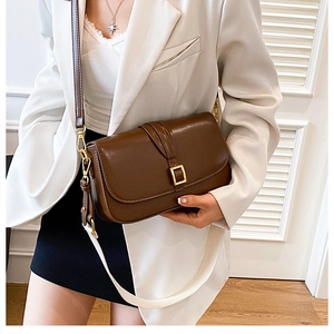 Detail view of a vintage dark brown shoulder bag with a square gold metal buckle