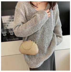 Champagne gold glitter evening bag worn with a delicate metal chain strap on outfit