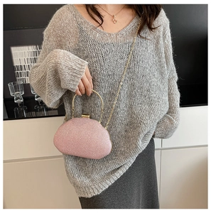 Close-up of pink glitter evening bag with gold chain strap and metal handle for women