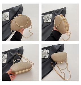 Detail of glittery gold evening box bag featuring metal handle and detachable chain strap