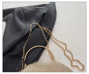 Macro detail of golden sequin evening clutch with metallic chain strap and round handle