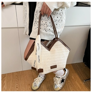 Detail of the woven tote bag showing V-shape opening and ribbon wrapped handles