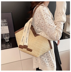 Detail of retro straw tote bag with leather trim and branded cream webbing strap