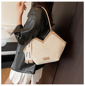 Detail of beige woven tote bag with V-shaped opening and stylish contrast ribbon