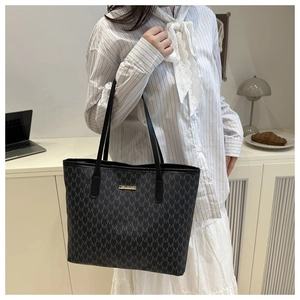 Détail du sac cabas monogramme vintage avec anses en cuir et logo en métal doré