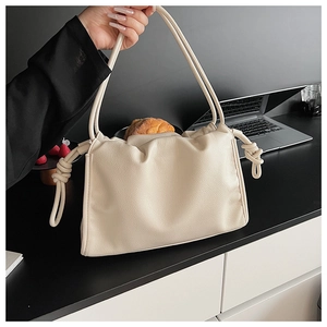 Détail de la texture en similicuir souple crème et des plis élégants du sac nuage