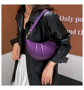 Detail of pleated purple crescent shoulder bag with golden metal hook and leather strap