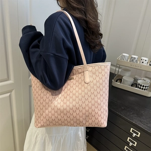 Sac cabas en cuir rose avec imprimé monogramme M porté par un mannequin à la maison