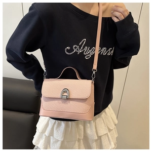 Pink crossbody bag featuring woven texture and silver horseshoe buckle on a female model