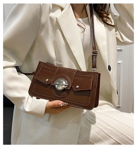 Détail du sac bandoulière vintage marron foncé avec boucle métallique argentée