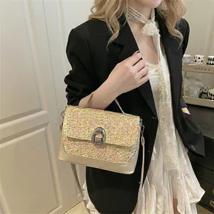 Elegant cream woven patchwork handbag with silver horseshoe buckle and adjustable strap