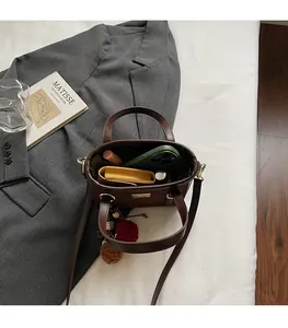 Interior view showing large capacity of the brown faux leather bucket bag with accessories