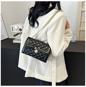 Close-up of black quilted shoulder bag featuring a unique gold rabbit-shaped twist lock