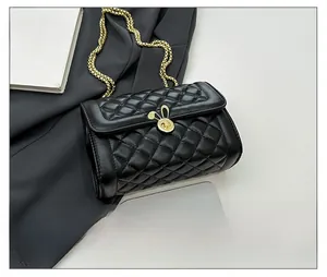 Detail shot of black quilted crossbody bag featuring a golden rabbit-shaped metal clasp