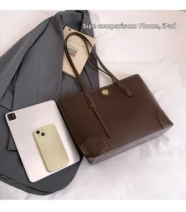 Macro shot of large dark brown leather tote bag holding a tablet and smartphone