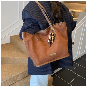 Sac cabas en daim marron avec perles en bois colorées et plaque logo en métal