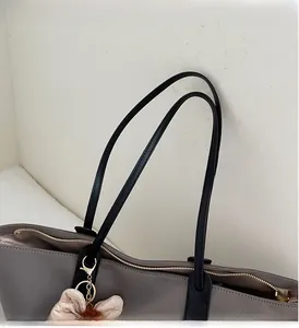 Détail du sac cabas gris montrant la fermeture éclair et les anses de transport