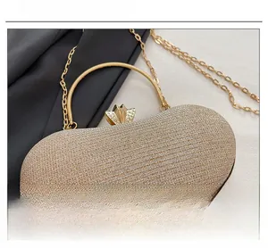 Detail of glitter evening bag showing champagne gold fabric and rhinestone petal clasp