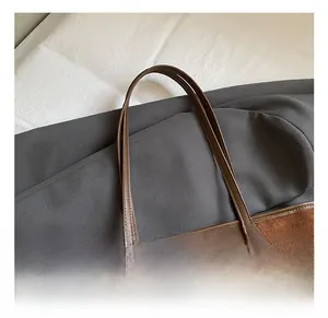 Détail d'un sac cabas en daim marron avec perles ethniques et bandoulière en cuir fin