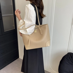 Minimalist beige pebble leather tote bag with gold M logo and long shoulder straps