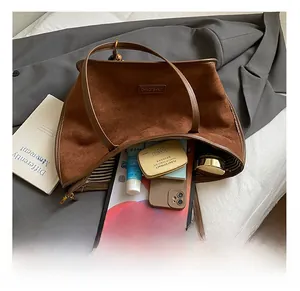 Vue intérieure montrant la grande capacité pour iPad et cosmétiques du sac en daim marron