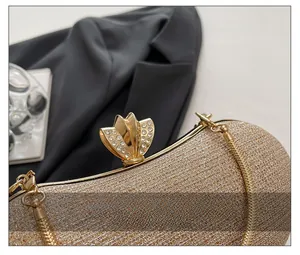 Detail of glitter champagne evening bag with crystal flower clasp and gold chain strap