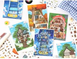 Detailed close-up of 3D landscape stickers and fantasy illustration cards on an art desk