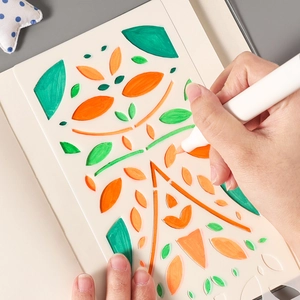 Reusable PET stencil set with geometric leaf patterns and marker on drawing notebook