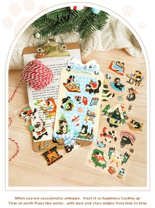 Detailed view of cute cartoon black cat and dog stickers in a cozy winter holiday setting