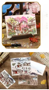 Detailed view of vintage Chinese style scenery stickers and decorative cards on a wooden desk