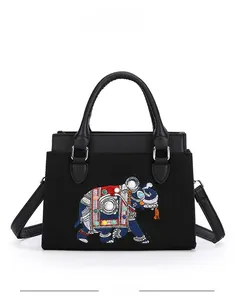 Détail du sac en tweed noir avec broderie éléphant ethnique et perles blanches décoratives
