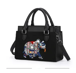 Gros plan détaillé de la broderie éléphant et des perles sur le sac à bandoulière noir
